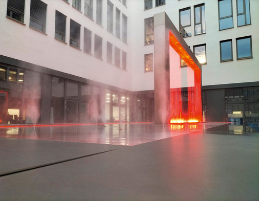 Brunnen im Hof des Karlsruher Smart-Tech-Zentrums erzeugt Lichteffekte im Farbnebel: Symbolik für effizienten Energiestrom aus der Datenwolke?