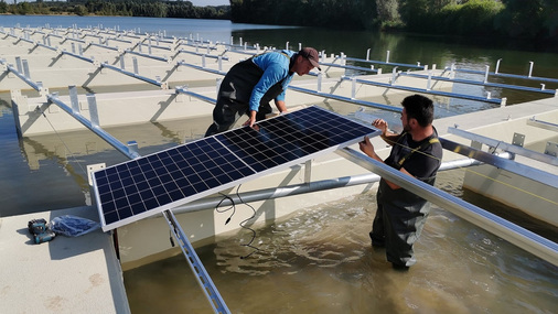 <p><strong>Floating PV im Kieswerk</strong></p><p>Die Module werden installiert, wenn die gesamte Unterkonstruktion im Wasser ist.</p> - © Foto: Rheinland Solar
