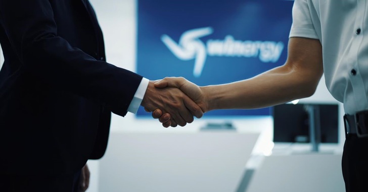 Alt-Text-Vorschlag: „Zwei Geschäftsleute in formeller Kleidung reichen sich in einem modernen Konferenzraum die Hand; im Hintergrund ist das verschwommene Logo eines Unternehmens für erneuerbare Energien zu erkennen – symbolisiert erfolgreiche Partnerschaften und Vertragsabschlüsse im Bereich Windenergie, Photovoltaik oder Wasserstoff-Technologien.“. - © Flender GmbH Alt-Text-Vorschlag: „Zwei Geschäftsleute in formeller Kleidung reichen sich in einem modernen Konferenzraum die Hand; im Hintergrund ist das verschwommene Logo eines Unternehmens für erneuerbare Energien zu erkennen – symbolisiert erfolgreiche Partnerschaften und Vertragsabschlüsse im Bereich Windenergie, Photovoltaik oder Wasserstoff-Technologien.“. - © Flender GmbH