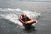 Das kleine Serviceboot auf dem Weg zum Anlanden an das neue Schiff.