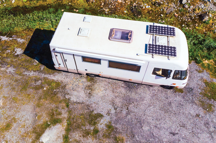 Camper mit Solarpanelen auf dem Wohnwagendach wie hier sind auf Kühlung für ihre Solarladeregler angewiesen.  