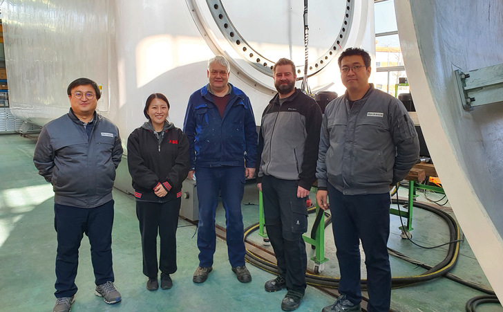 Thorsten Spehr, 3. v. l., mit Kollegen und Kunden von Hanjin und der neuen von Idaswind entworfenen Turbine im Hintergrund in einer Produktionshalle in Südkorea. - © Foto: Idaswind

