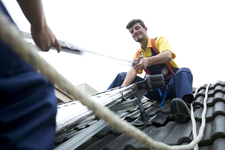 Anlagenmechaniker bei der Installation einer Solarthermie-Anlage. - © ZVSHK
