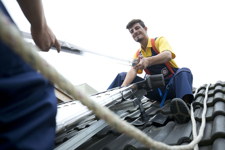Anlagenmechaniker bei der Installation einer Solarthermie-Anlage.