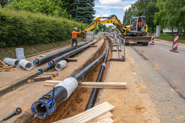 Arbeiter verlegen den Strang eines städtischen Fernwärmenetzes. - © Photoagriculture - stock.adobe.com
