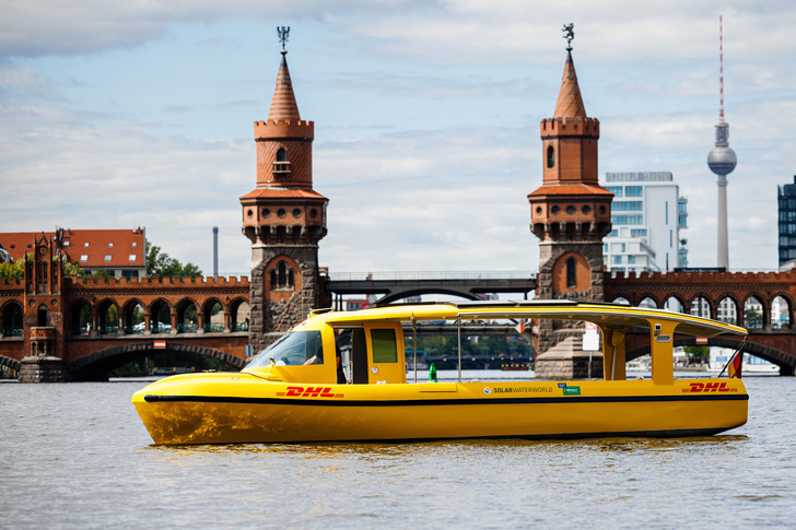 Das Päckchen kommt per Solarschiff: Paketzustellung in Berlin. An der Oberbaumbrücke wird es allerdings nicht verkehren, sondern zwischen Südhafen Spandau und Westhafen. - © Deutsche Post DHL Group/Jens Schlueter
