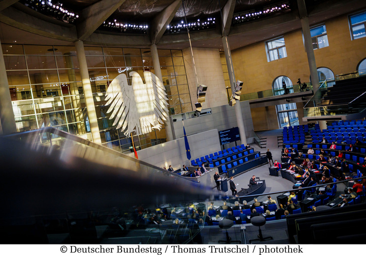 Die tief stehende Sonne beleuchtet den Plenarsaal: Blick auf den Bundestagsadler und ins Plenum. - © Thomas Trutschel / photothek - Deutscher Bundestag
