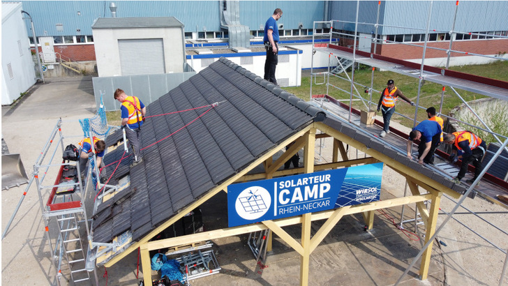 An einem eigens dafür aufgebauten Dachmodell im Camp Rhein-Neckar von Wirsol üben angehende Installateure die Montage von Solaranlagen. - © Steffen Hoffner
