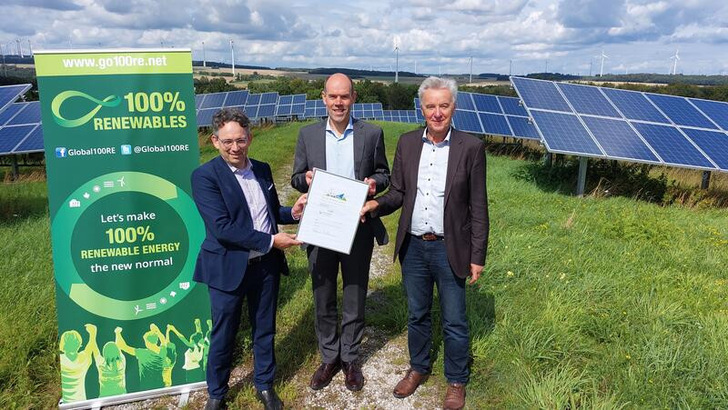 Die Auszeichnung für den Rhein-Hunsrück-Kreis zur 193-Prozent -Vollversorgung durch Stefan Gsänger (links) als Vorstand der Global 100% Renewable Energy Platform sowie Generalsekretär der Windenergieorganisation WWEA und durch den Iniatator des Auszeichnungsprojektes Johannes Lackmann (rechts), Chef beim Windenergieunternehmen Westfalenwind. Landrat Volker Boch nimmt die Auszeichnung entgegen.