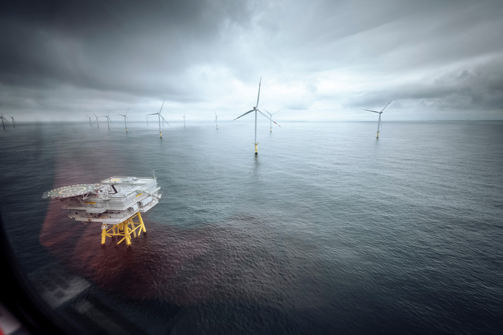 Blick aus einem Helikopter auf den Windpark Riffgat mit dem Umspannwerk im Vordergrund.