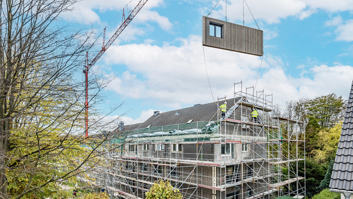 Die vorgefertigten Fassadenbauteile werden direkt vor die bestehende Außenwand gehängt.
