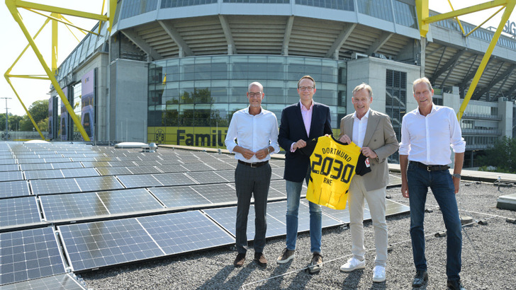 Auf dem Dach der Fanwelt des BVB ist schon eine Solaranlage installiert. Der Generator auf dem Stadiondach folgt bald. Carsten Cramer, Geschäftsführer des BVB, Markus Krebber, CEO von RWE, Hans-Joachim Watzke, Vorsitzender der Geschäftsführung des BVB, und Ulf Kerstin, CCO von RWE Supply & Trading (v.l.n.r.), besiegeln die neue Energiepartnerschaft.