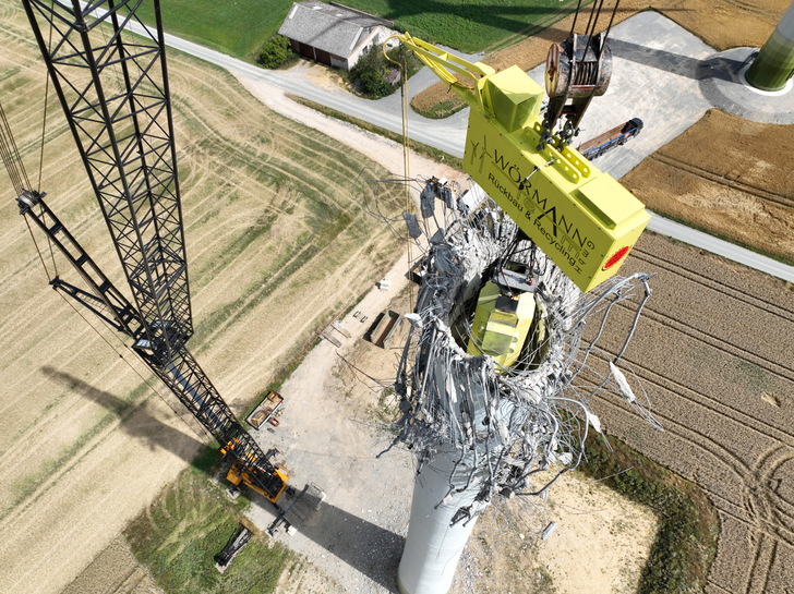 Rückbau eines Betonturms mit einer Traverse. Diese Technik von Wörmann-Team vermeidet, dass der Turm gefällt werden muss.