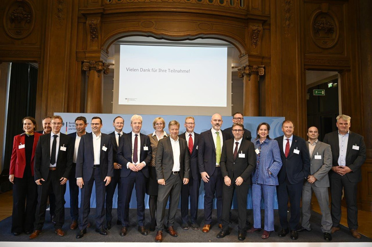 Bundeswirtschaftsminister Robert Habeck (Mitte, ganz vorne) und die Firmenvertreter der Industrieunternehmen, die nun einen Klimaschutzvertrag mit dem Staat erfüllen wollen und ihre Fertigung auf Klimaneutralität umrüsten. 