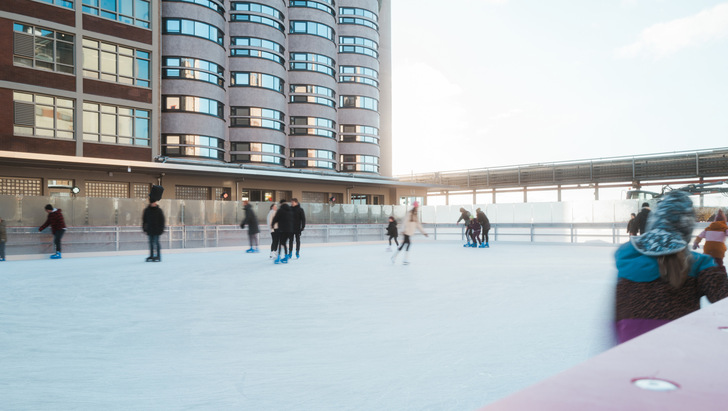 Eislaufbahn über dem Oberflächenkaltwasserspeicher des Bremer Überseeinsel-Quartiers vor dem zum Hotel umgebauten ehemaligen Kellogg-Speichersilo
