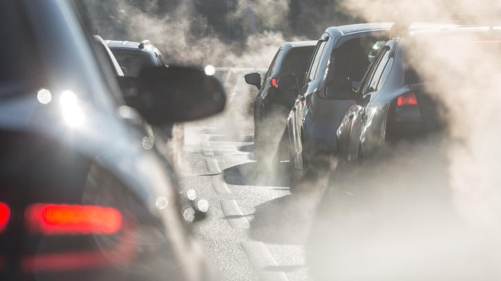 Im Stau stehende Autos stoßen Abgase aus und sorgen so für eine rauchige und verschmutzte Atmosphäre auf der Straße. - © elcovalana - stock.adobe.com