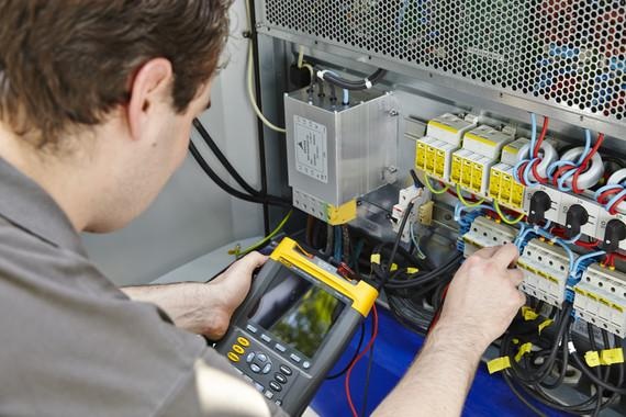 Ein Servicetechniker im Einsatz. Er überprüft die Schaltschränke.