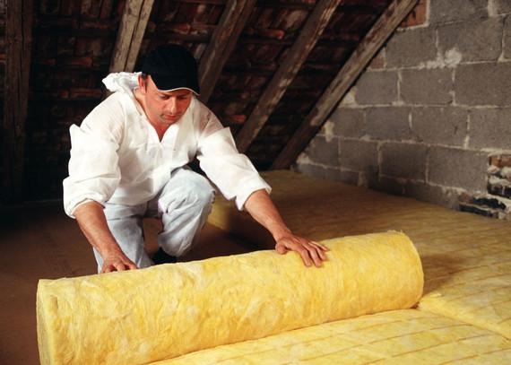 Ausrollen von Dämmwolle zur Dämmung der obersten Geschossdecke