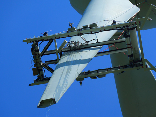 An einem Seil hängend inspiziert das System das Rotorblatt vertikal.