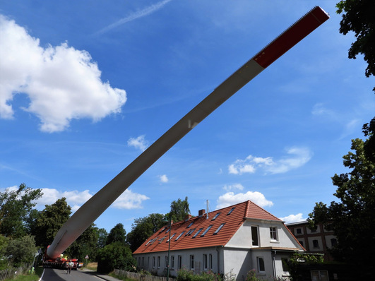 Symbolbild, Juli 2023, Blatttransport für GE-windpark Milow, Bei dem Rotorblatt, welches auf dem Bladelifter montiert ist, handelt es sich um ein Teilstück mit einer Länge von 65 m. Die Blattspitze mit 12 m Länge wird separat angeliefert und auf der Baustelle mit dem Hauptteil verbunden. Daraus ergibt sich eine Gesamtlänge von 77 Meter. Drei Windturbinen von GE 5.5-158 ersetzten hier zwölf Altanlagen.