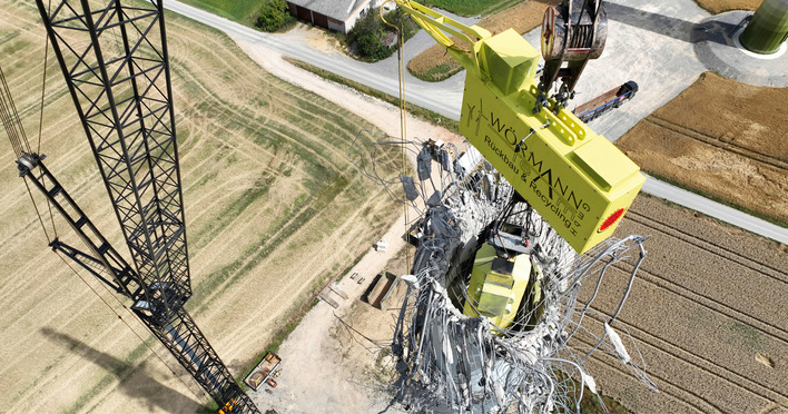 Rückbau eines Betonturms mit einer Traverse, die den Betonturm von oben nach unten und von innen nach außen zerdrückt. Diese Technik von WÖRMANN TEAM vermeidet, dass der Turm gesprengt werden muss.