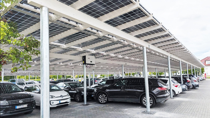 Die Kombination aus semitransparenten Solarmodulen und weißen Holzbalken sorgen für eine hochwertige Ästhetik.