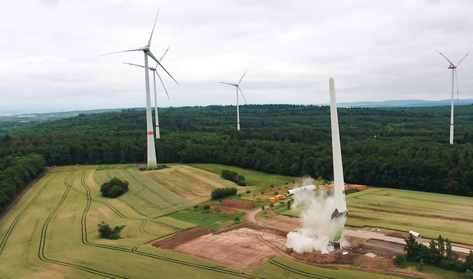 Geplanter Einsturz mit gleichzeitigen gegenläufigen Sprengungen an Fundament und Turm.
