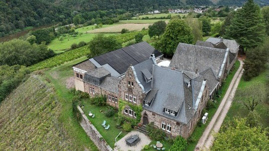 Die denkmalgeschützte Kelterei, errichtet 1905 als Neo-Renaissancebau. Auf der Lagerhalle wurde eine PV-Anlage installiert, die 71.828 kWh pro Jahr erzeugt.