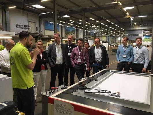 Jan Philipp Braß, Leiter der Adler Solar Wechselrichter Services und des Test- und Reparaturcenters für PV-Module, erklärt Besuchern, welche Stationen die Module durchlaufen, um auf Schäden geprüft zu werden.