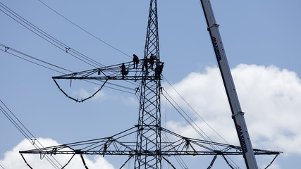 Freileitungsmonteure beim Aufbau eines neuen Strommastes.